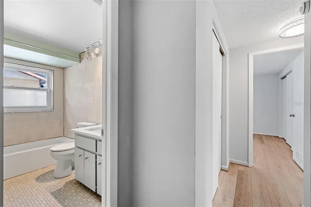 a bathroom with a granite countertop toilet a sink and a mirror