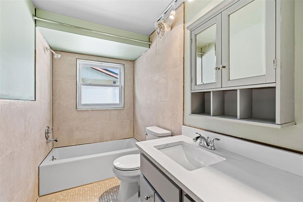 10187 122nd Avenue Largo, FL 33773 - Photo 31 of 48 a bathroom with a granite countertop sink toilet and shower