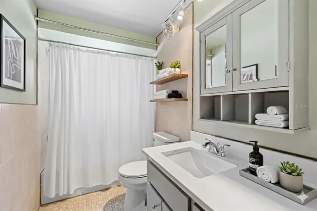 a bathroom with a sink a toilet and shower curtain