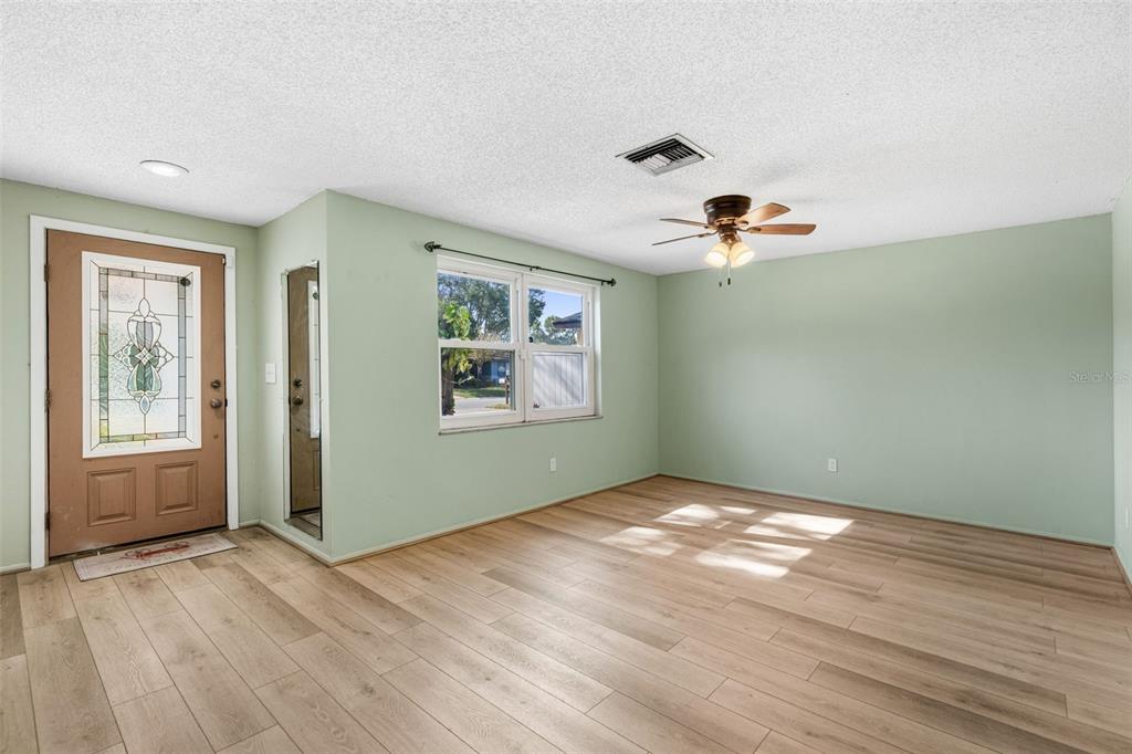 10187 122nd Avenue Largo, FL 33773 - Photo 8 of 48 a view of an empty room with window and wooden floor