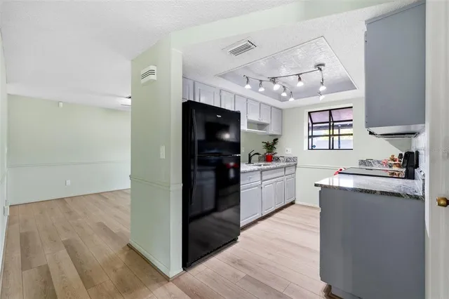 a kitchen with granite countertop a refrigerator stove top oven and sink
