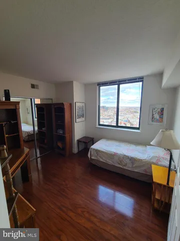 a bedroom with a bed and wooden floor