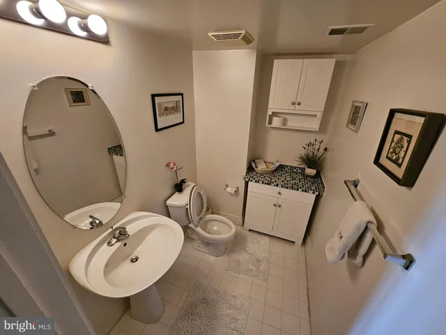 a bathroom with a sink mirror and toilet