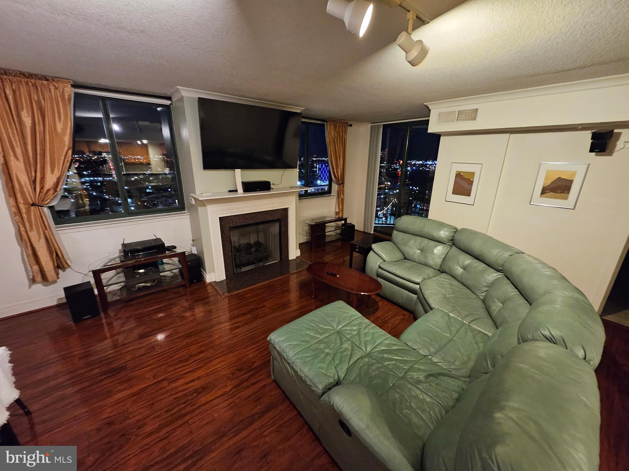 414 Water Street, Unit 2613 Baltimore, MD 21202 - Photo 2 of 42 a living room with furniture flat screen tv and a fireplace