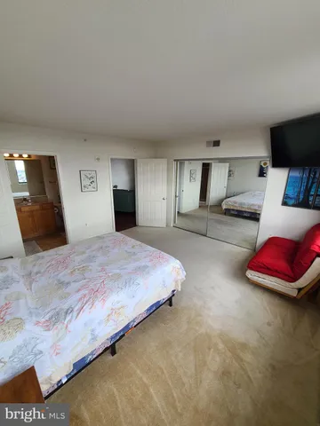 a bedroom with a bed and a large mirror