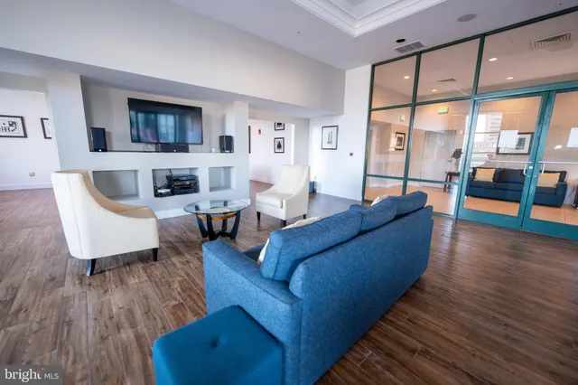 a living room with furniture wooden floor and a large window