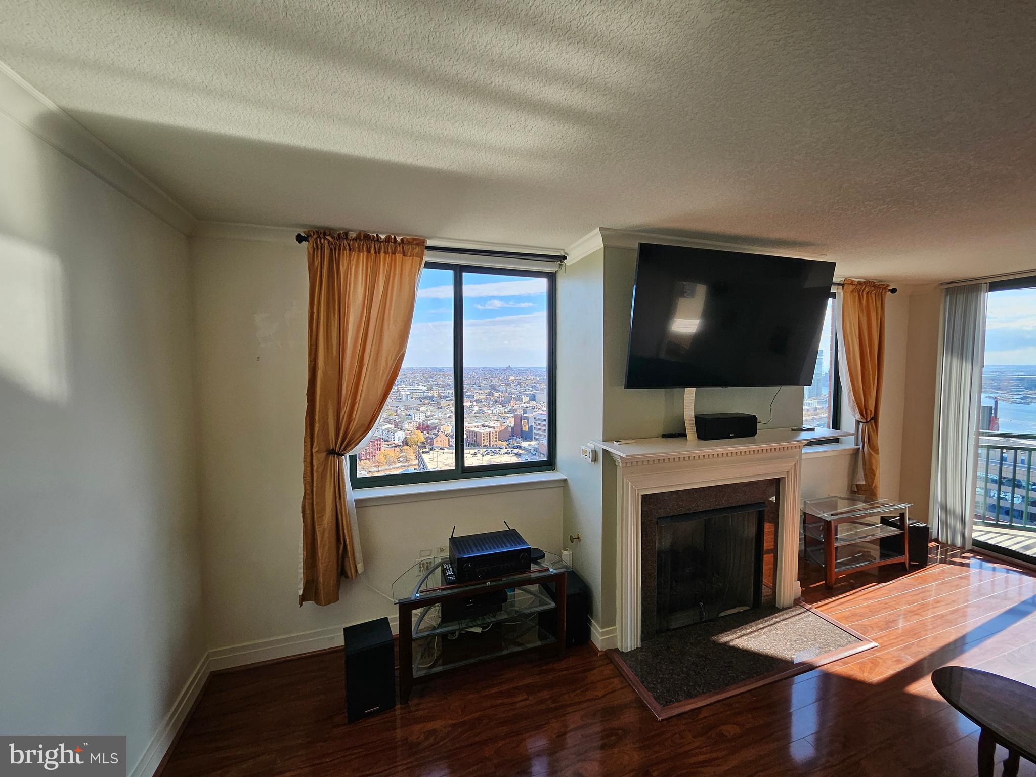 414 Water Street, Unit 2613 Baltimore, MD 21202 - Photo 5 of 42 a living room with furniture a flat screen tv and a fireplace