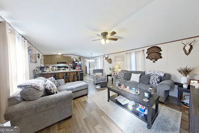 a living room with furniture and a ceiling fan