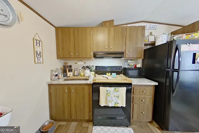 a kitchen with stainless steel appliances granite countertop a refrigerator a stove and a sink