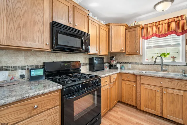 a kitchen with granite countertop a stove a sink and a microwave