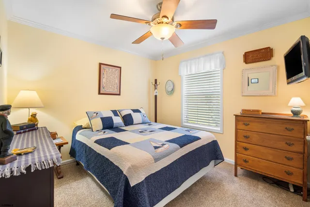 a bedroom with a bed and a flat tv screen on dresser