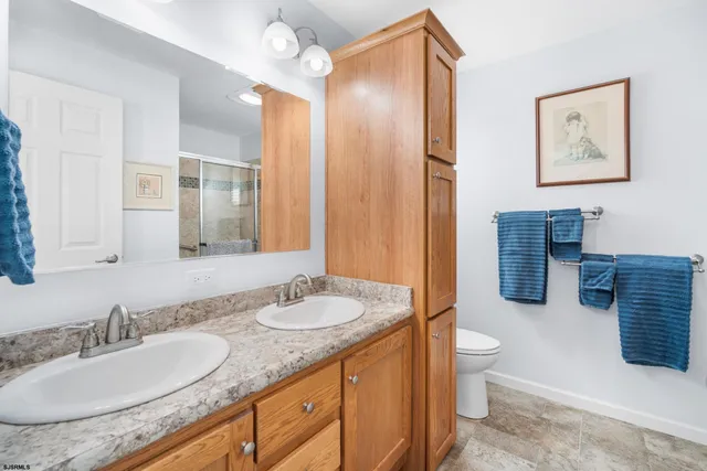 a bathroom with a granite countertop sink mirror and toilet