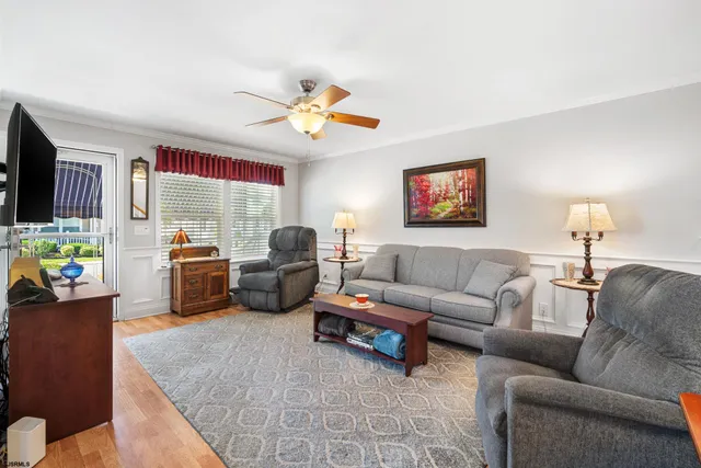 a living room with furniture a flat screen tv and a window