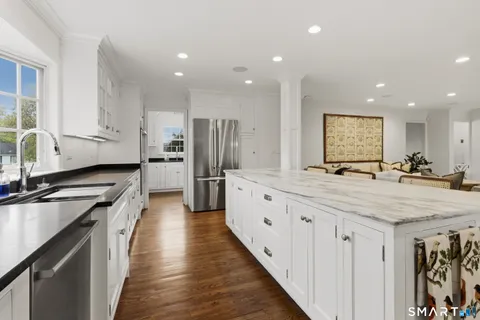 a kitchen with stainless steel appliances granite countertop a sink a stove and cabinets