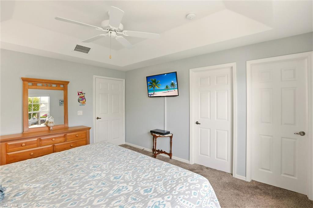 218 Marseille Drive Naples, FL 34112 - Photo 24 of 34 a bedroom with a bed and a chandelier