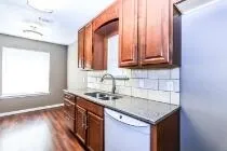 a kitchen with stainless steel appliances granite countertop a sink a microwave cabinets and a wooden floor