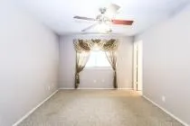 a view of a room with a chandelier fan and windows