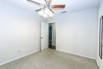 an empty room with a chandelier fan and a fan