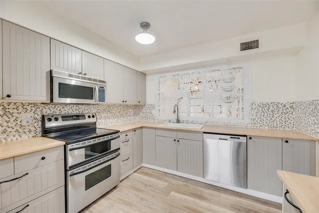 a kitchen with granite countertop cabinets stainless steel appliances and a sink