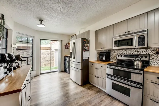 a kitchen with stainless steel appliances a stove microwave and sink