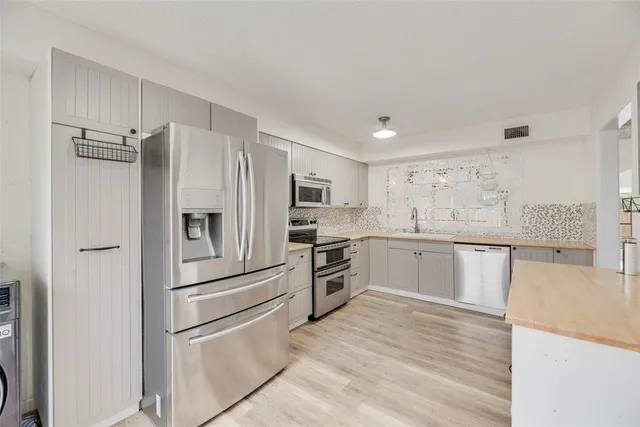 a kitchen with granite countertop stainless steel appliances and refrigerator