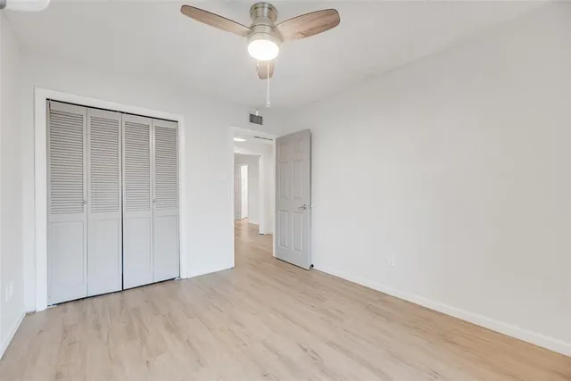 an empty room with a ceiling fan and hardwood floor