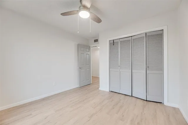 an empty room with a ceiling fan and a window