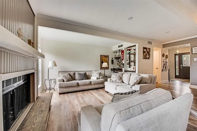 a living room with furniture a fireplace and a wooden floor