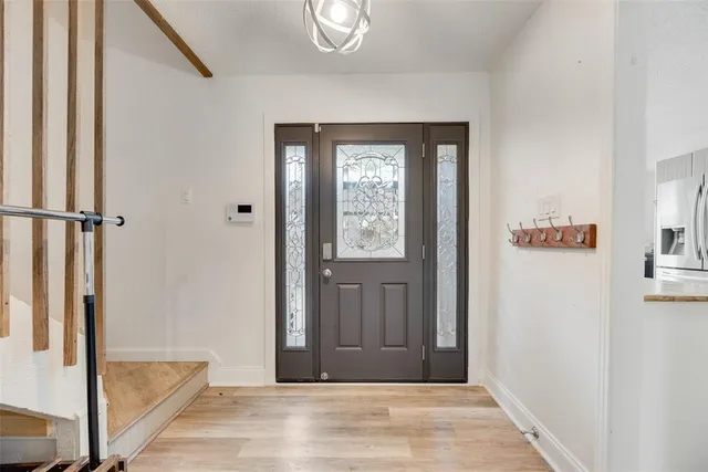 a view of a hallway with wooden floor and staircase