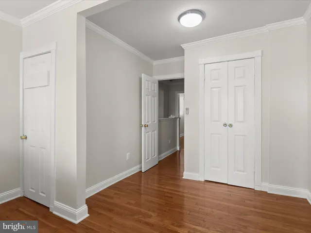 an empty room with wooden floor and closet