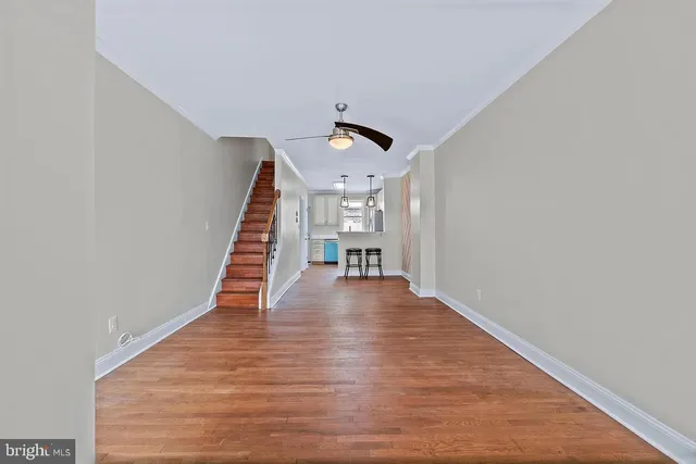 a view of a hallway with wooden floor and staircase