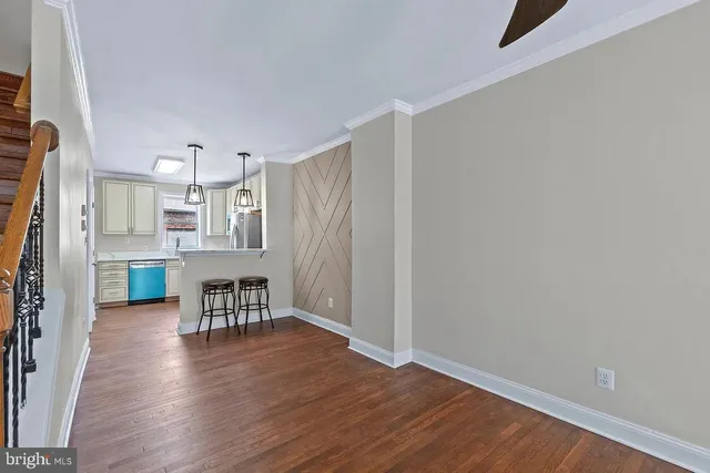 an empty room with wooden floor and furniture