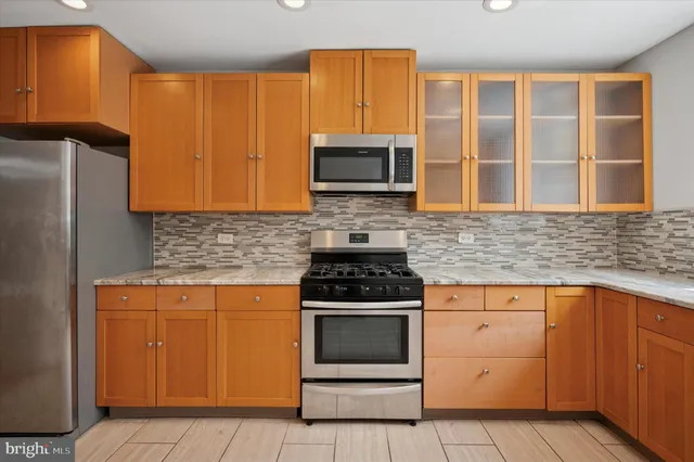 a kitchen with granite countertop cabinets stainless steel appliances and a sink