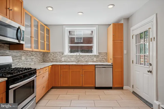 a kitchen with stainless steel appliances granite countertop a stove and a sink