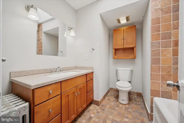 a bathroom with a toilet sink and mirror