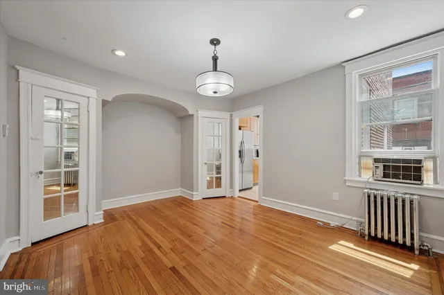 a view of a livingroom with wooden floor and windows