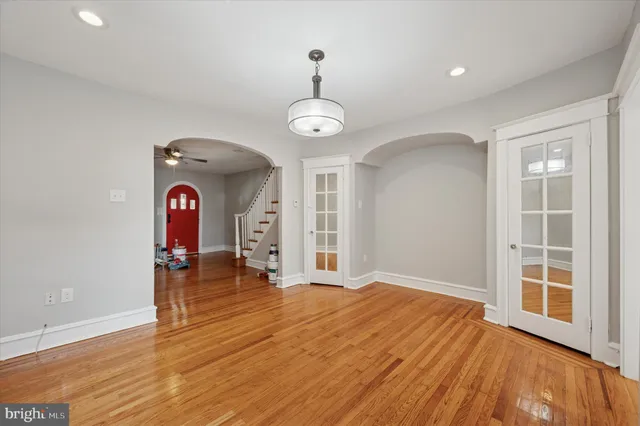 a view of empty room with wooden floor and window