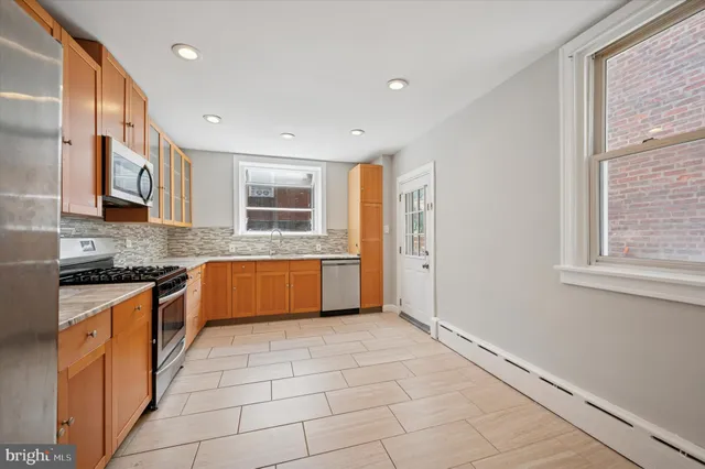 a large kitchen with stainless steel appliances granite countertop a stove and a sink