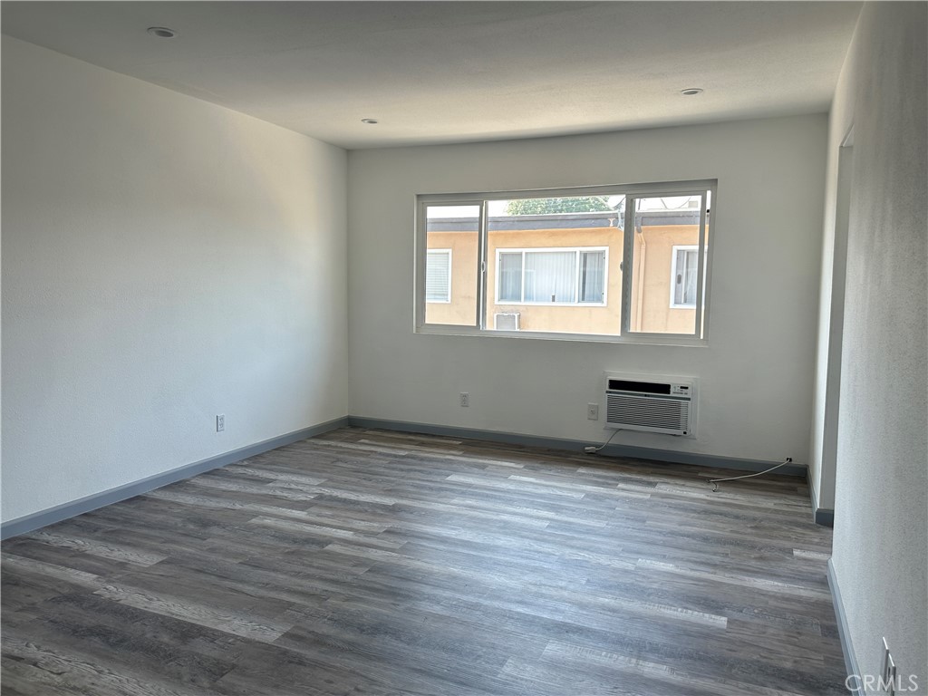 3060 Vineland Avenue, Unit 7 Baldwin Park, CA 91706 - Photo 6 of 14 an empty room with wooden floor and windows