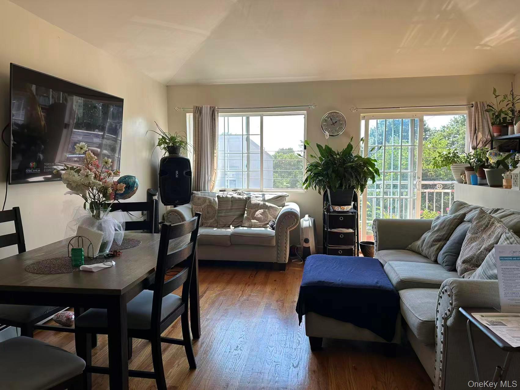 80-29 57th Street Queens, NY 11385 - Photo 11 of 12 Living room featuring wood finished floors and vaulted ceiling