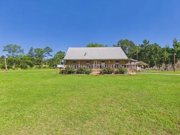 a view of a house with a yard and sitting area