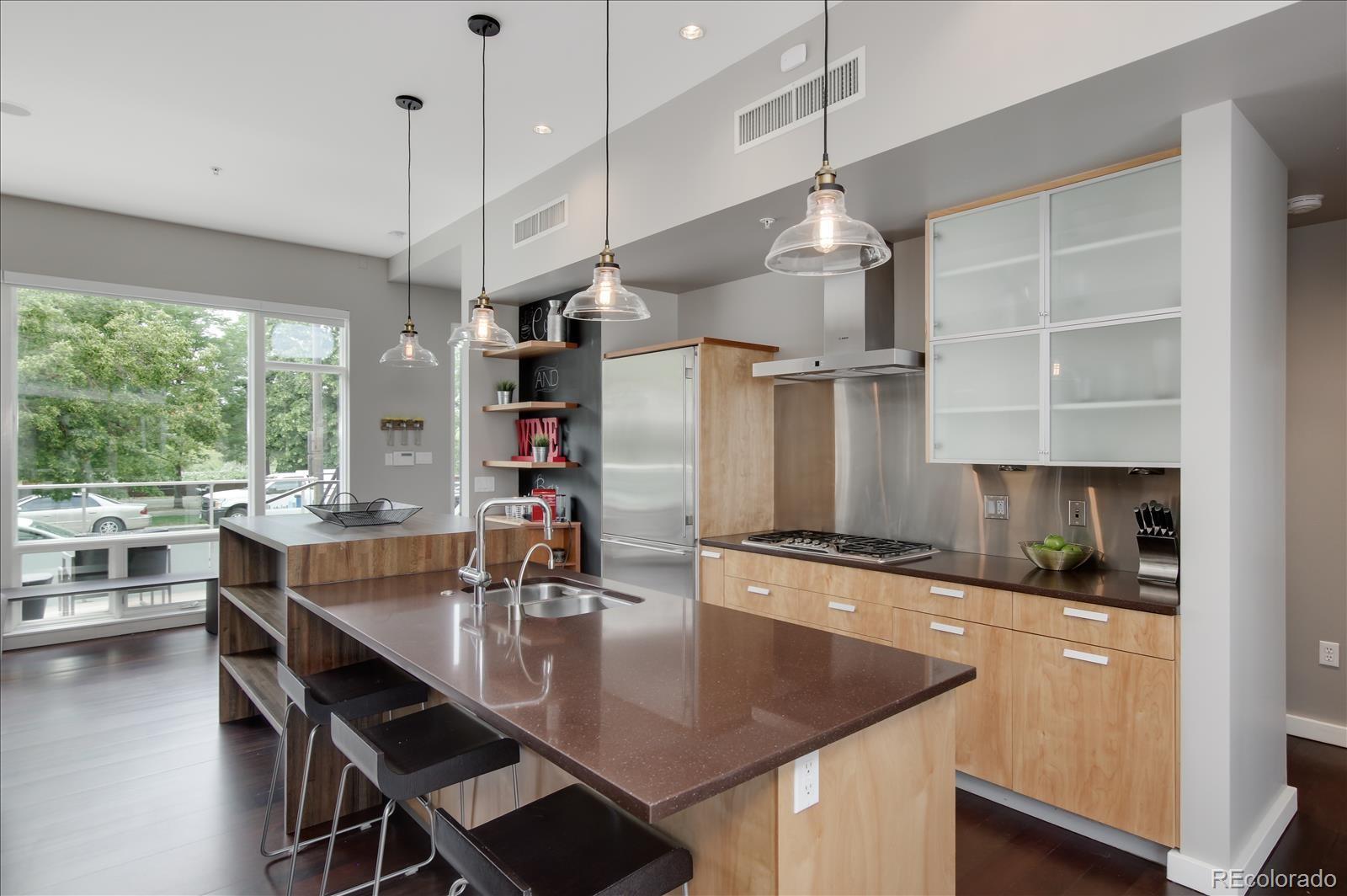 1640 Little Raven Street Denver, CO 80202 - Photo 11 of 37 a kitchen with stainless steel appliances granite countertop a sink a stove and a refrigerator