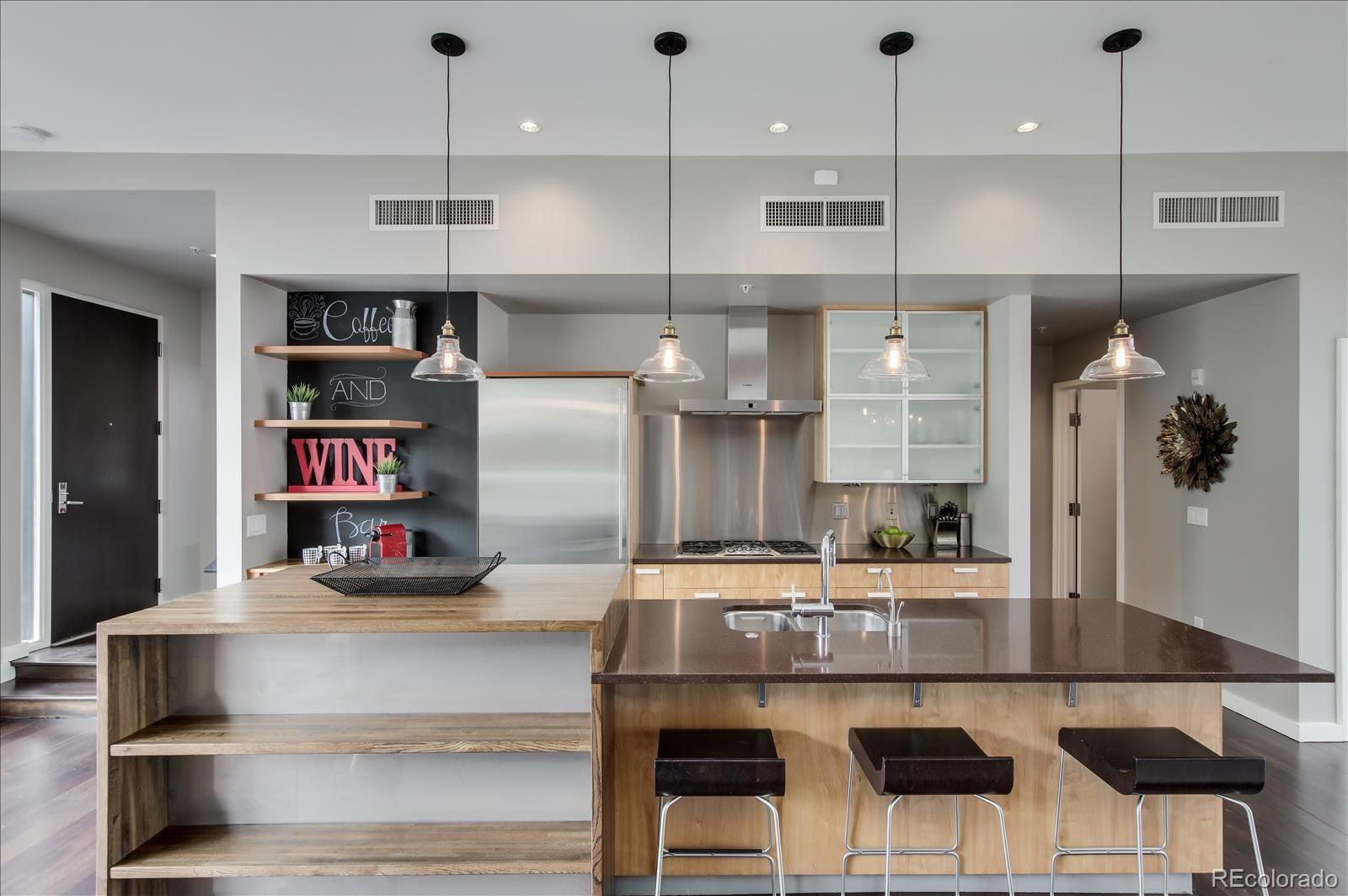 1640 Little Raven Street Denver, CO 80202 - Photo 12 of 37 a kitchen with kitchen island stainless steel appliances a refrigerator and counter space