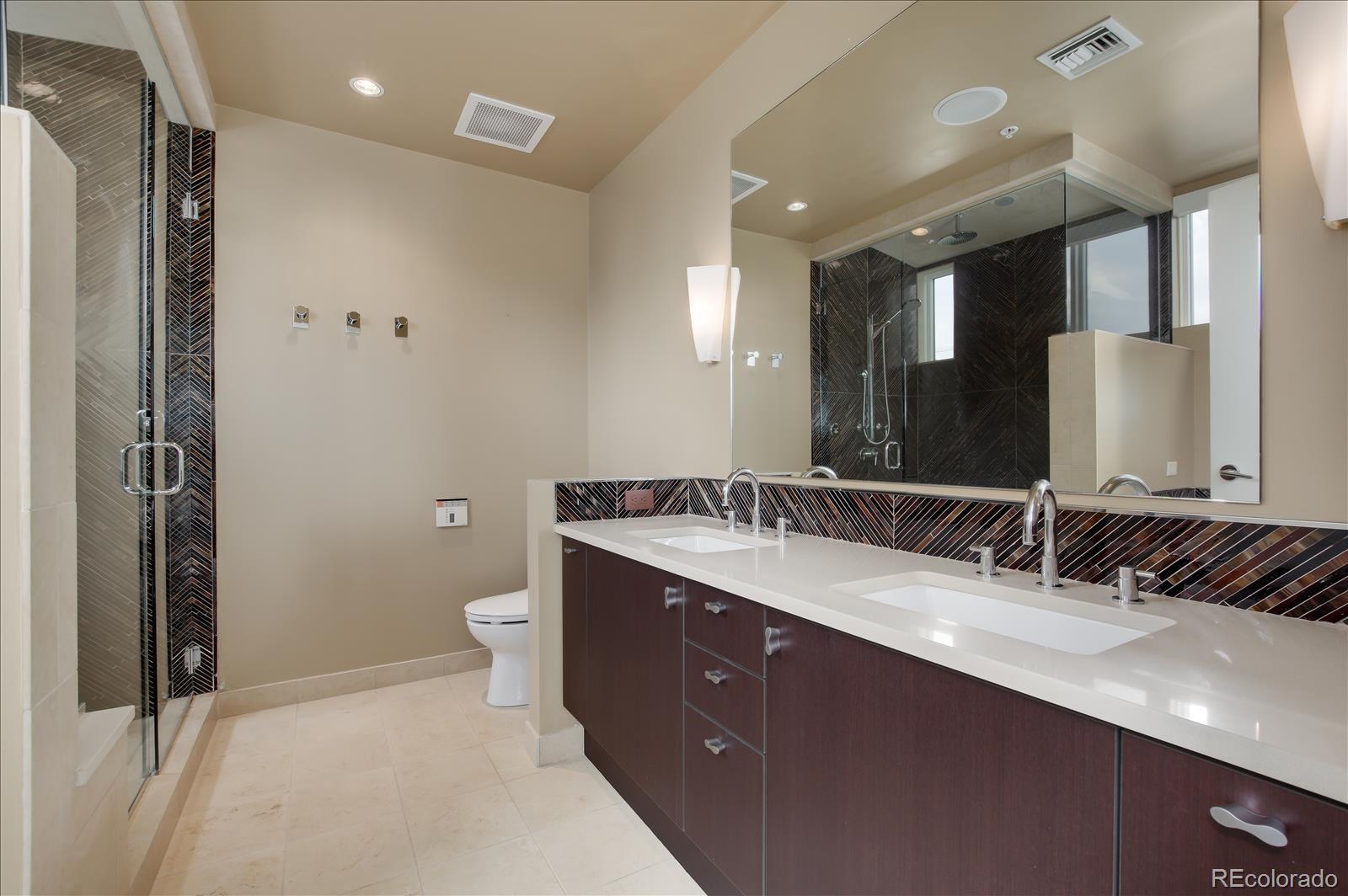 1640 Little Raven Street Denver, CO 80202 - Photo 22 of 37 a bathroom with a double vanity sink toilet and mirror
