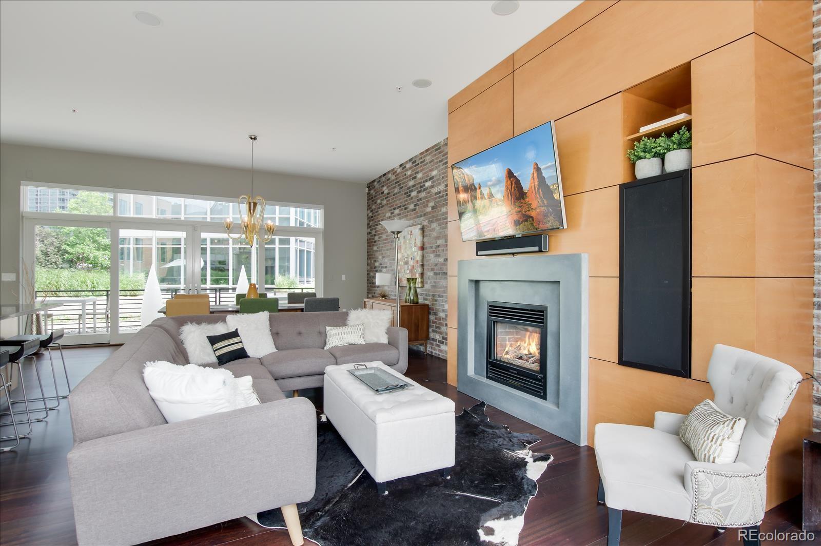 1640 Little Raven Street Denver, CO 80202 - Photo 6 of 37 a living room with furniture a fireplace and a large window