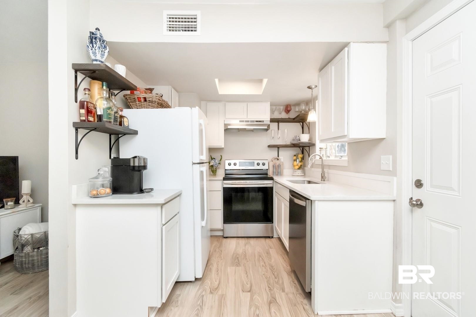 110 Du Rhu Drive, Unit C Mobile, AL 36608 - Photo 7 of 14 Kitchen featuring white cabinetry, sink, hanging light fixtures, appliances with stainless steel finishes, and light wood-type flooring