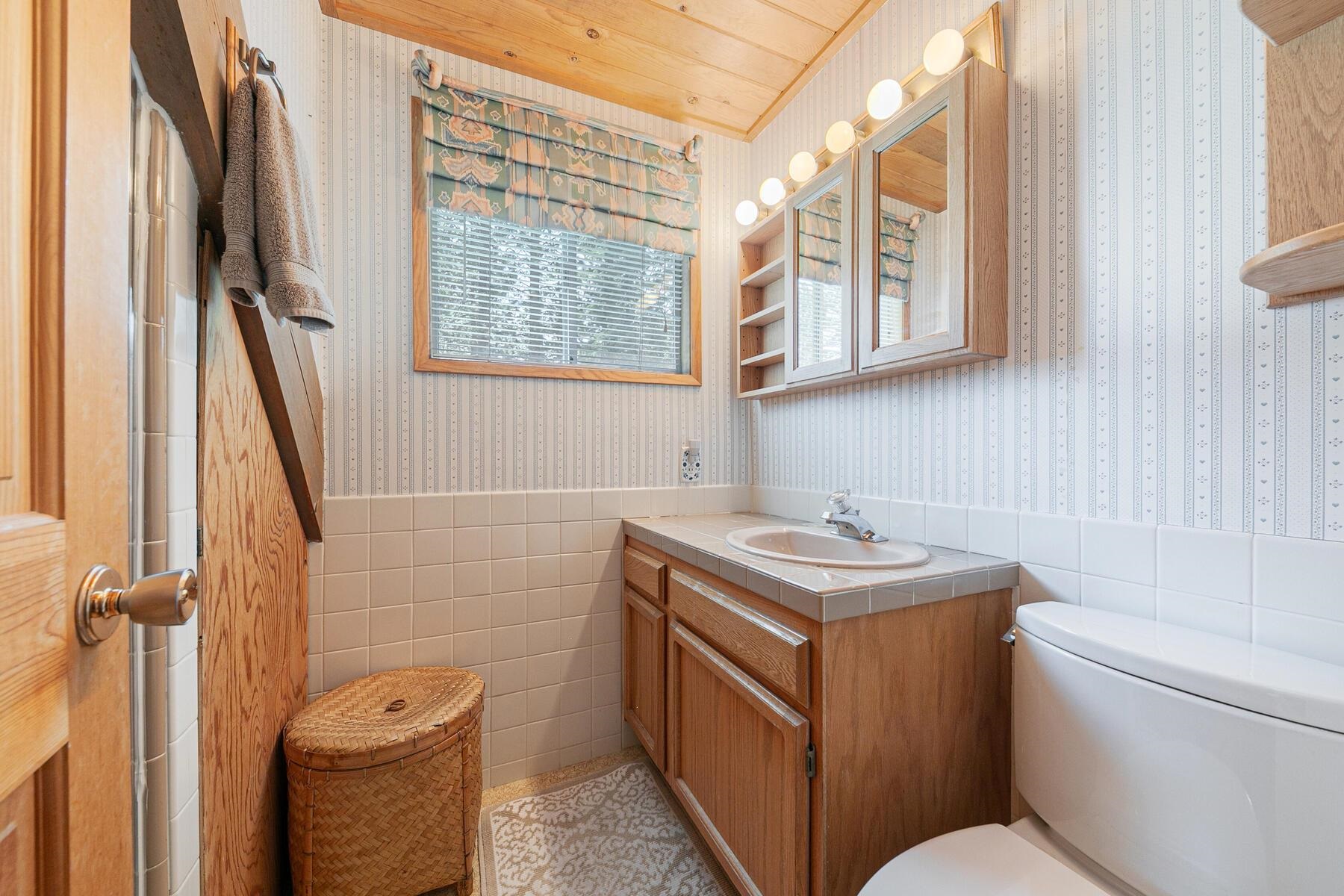 5775 Victoria Drive Carnelian Bay, CA 96140 - Photo 24 of 28 a bathroom with a granite countertop toilet sink and mirror
