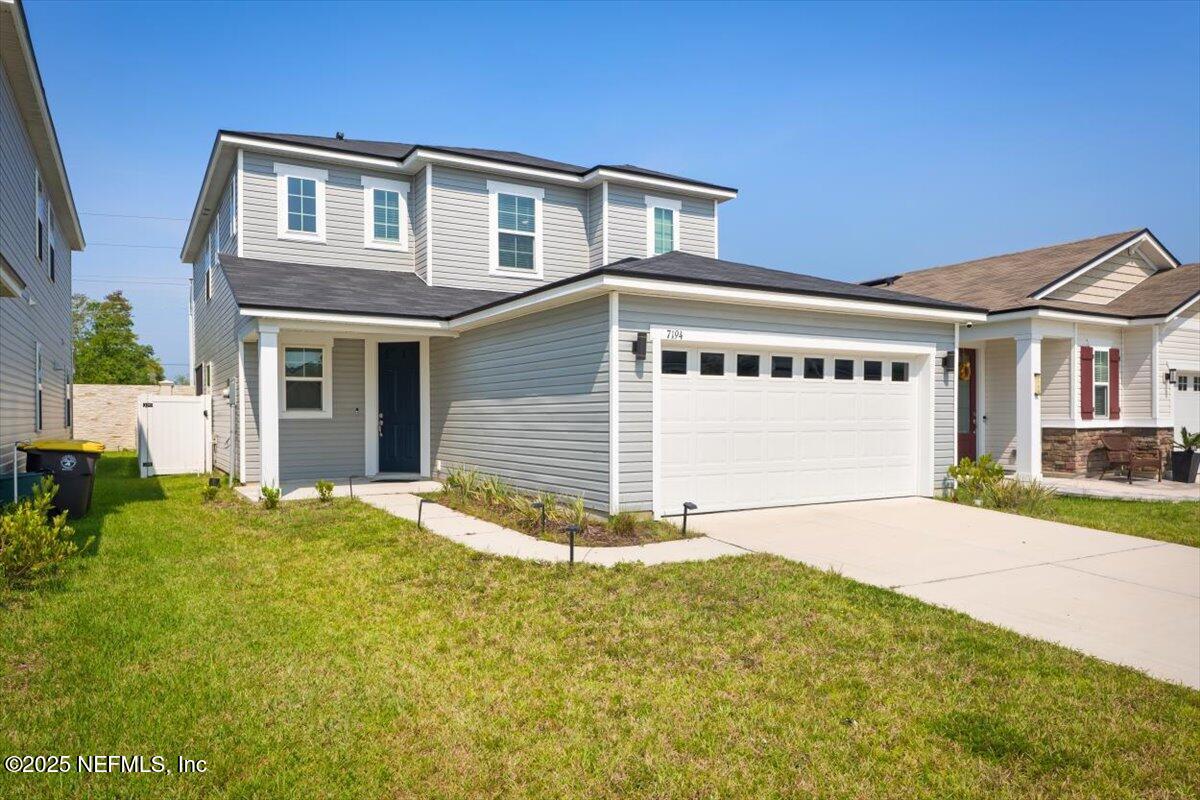 a front view of a house with a garden and yard
