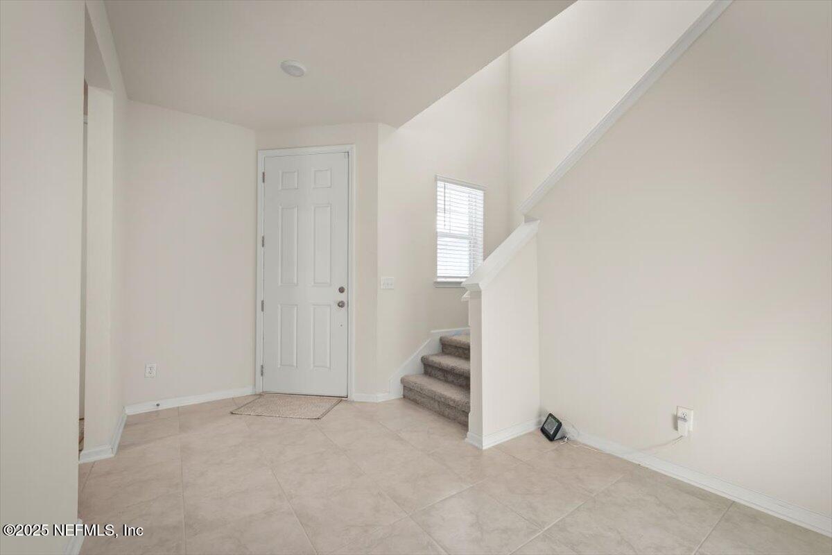 7194 Red Timber Road Jacksonville, FL 32244 - Photo 16 of 40 a view of an empty room with stairs and a window