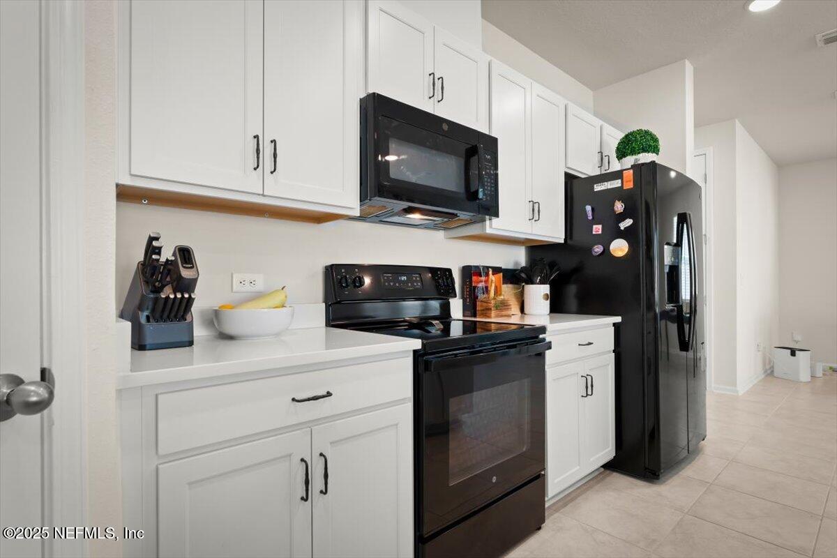 7194 Red Timber Road Jacksonville, FL 32244 - Photo 21 of 40 a kitchen with stainless steel appliances granite countertop a refrigerator and a stove top oven